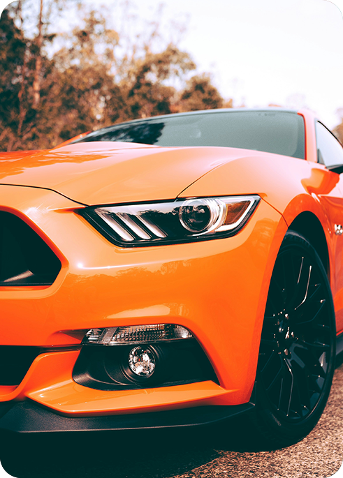 A right close up of a yellow Mercedes AMG sports car headlight on a city street