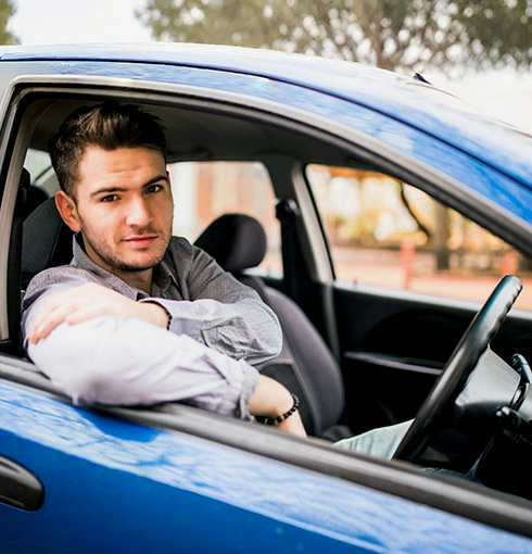 A right close up of a yellow Mercedes AMG sports car headlight on a city street