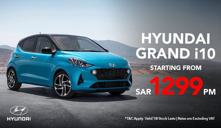 Hyundai Grand i10 parked on a city street, showcasing its sleek design and modern features. displaying starting price SAR 1299/month.