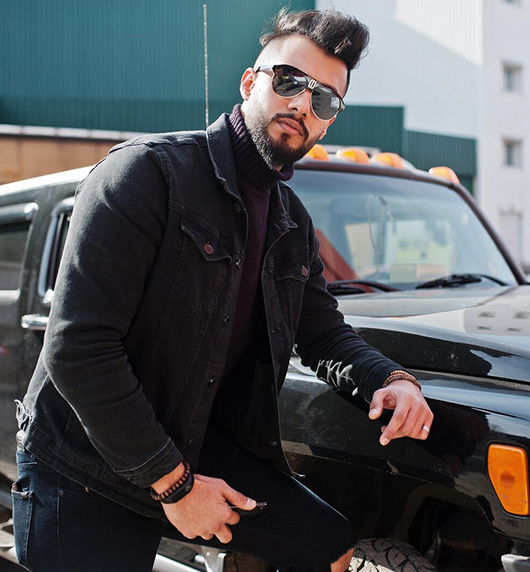 A right close up of a yellow Mercedes AMG sports car headlight on a city street